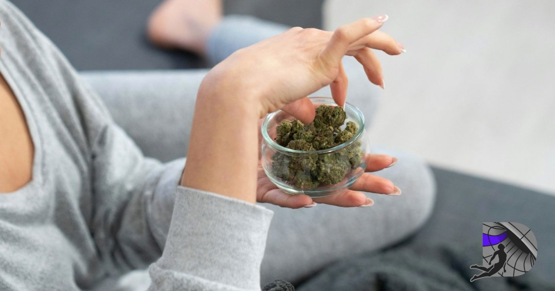 Hands holding a small glass container filled with high-quality cannabis flower buds.